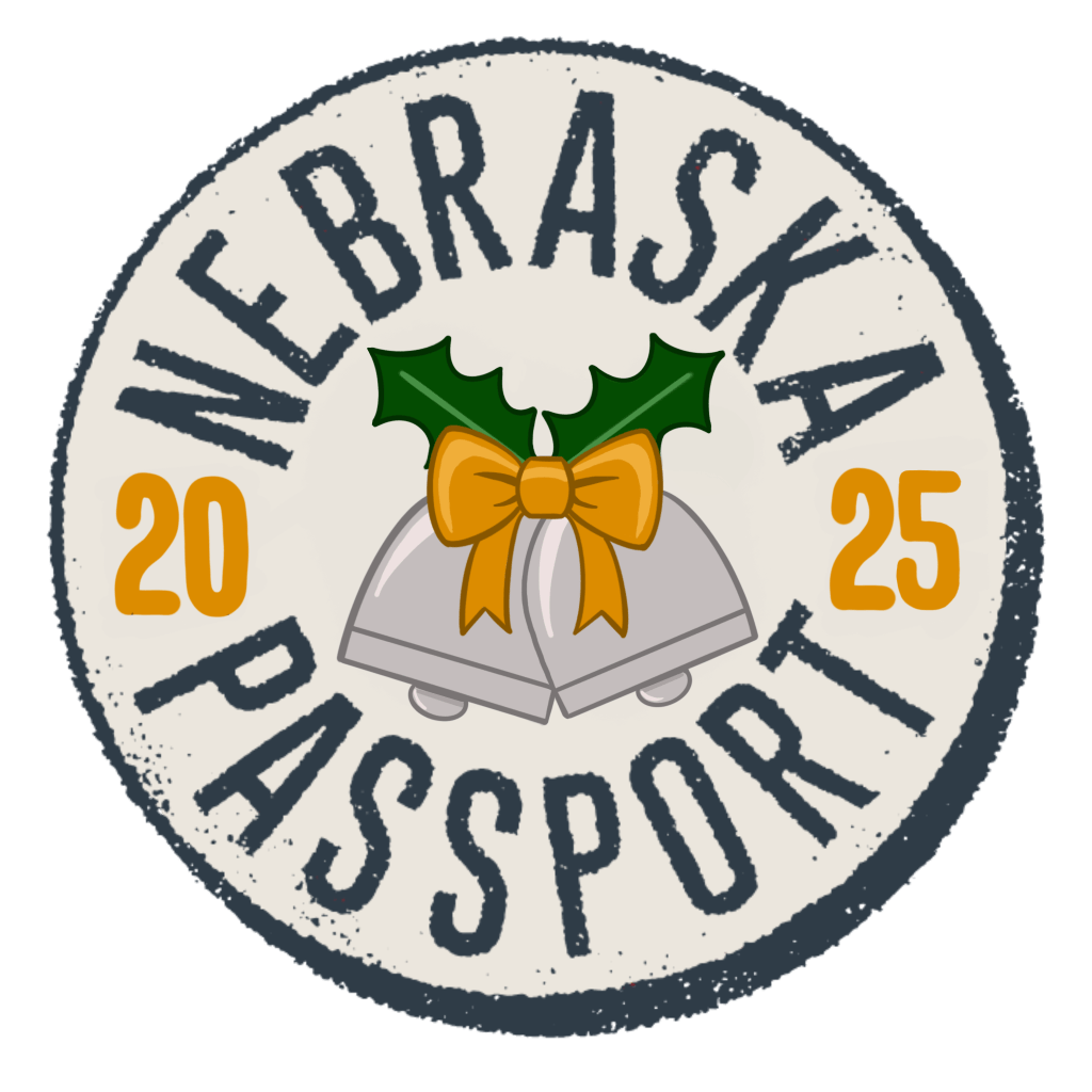 Logo for the Nebraska Holiday Passport program featuring the text 'NEBRASKA PASSPORT 20 25' alongside two bells and holiday decorations.